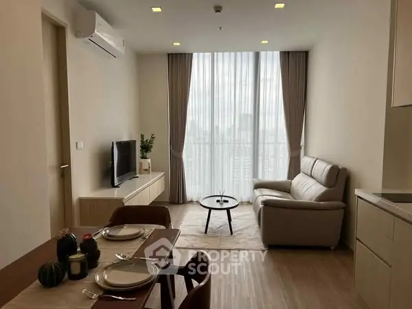 Modern living room with city view, featuring sleek furniture and natural lighting.