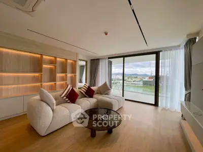 Spacious modern living room with large windows and scenic view, featuring cozy seating and elegant decor.