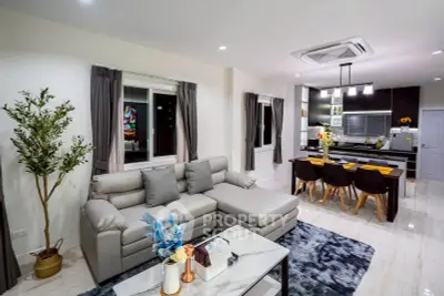 Modern open-layout living room and kitchen with stylish decor and cozy seating.