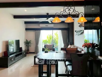 Spacious living room with modern decor and large window offering natural light and greenery view.