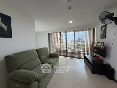 Spacious living room with large windows and city view, featuring a comfortable sofa and modern decor.