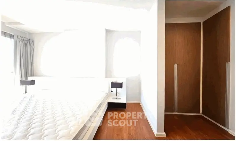 Bright bedroom with wooden flooring and built-in wardrobe