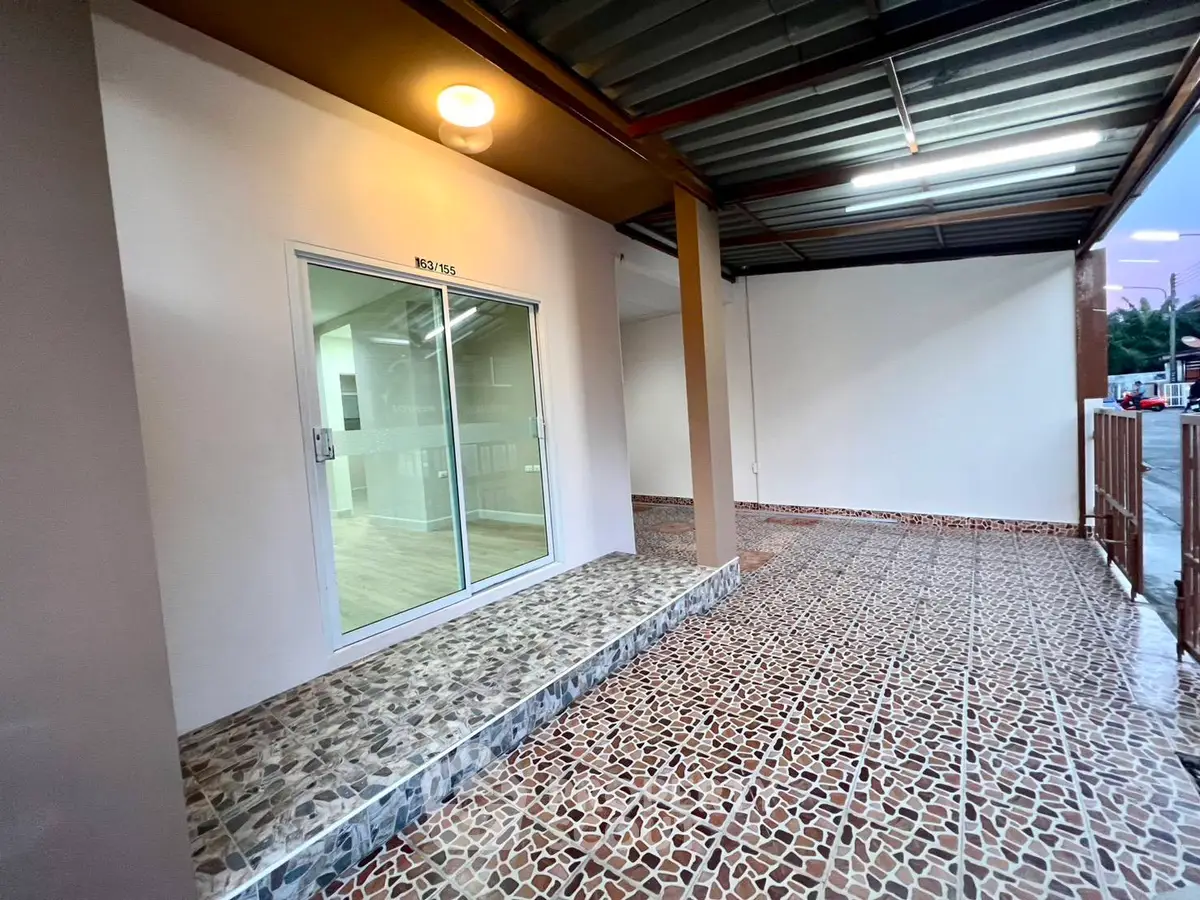 Modern exterior with tiled patio and glass door entrance, perfect for welcoming guests.