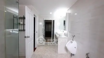 Spacious modern bathroom with dual sinks and glass shower enclosure