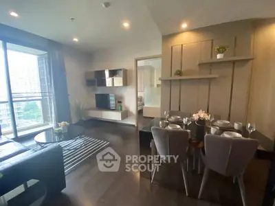 Modern living room with dining area and stylish decor in a high-rise apartment.