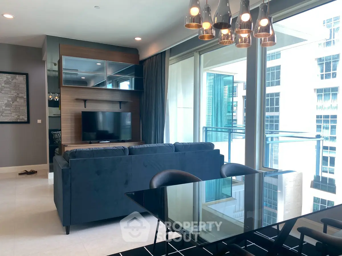 Modern living room with sleek furniture and large windows offering a city view.