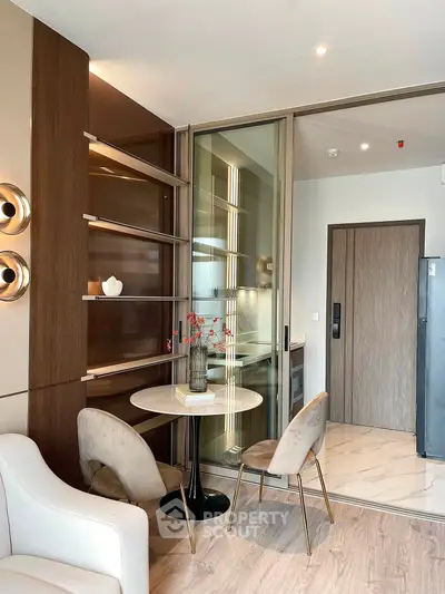 Modern living room with elegant dining area and sliding glass doors, featuring stylish decor and warm lighting.
