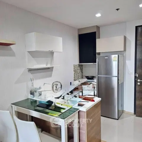 Modern kitchen with sleek design, featuring stainless steel fridge and stylish dining area.