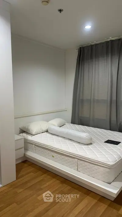 Cozy bedroom with modern decor and natural light, featuring a comfortable bed and stylish curtains.