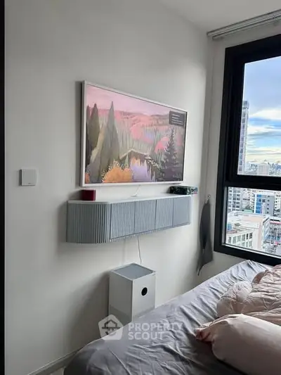 Modern bedroom with city view, stylish wall art, and sleek storage solutions.