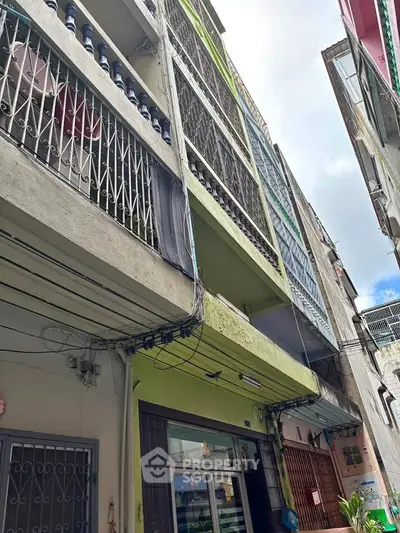 Explore this multi-story residential building with unique architectural features and vibrant facade.
