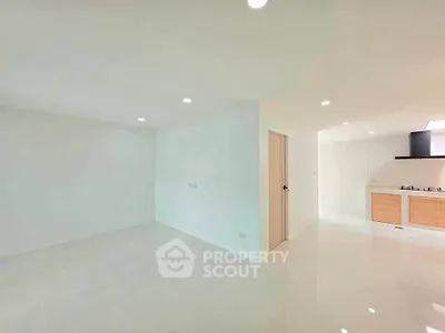 Spacious open-plan living area with modern kitchen and sleek finishes.