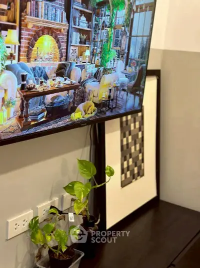 Stylish living room with wall-mounted TV and indoor plants, perfect for modern living.