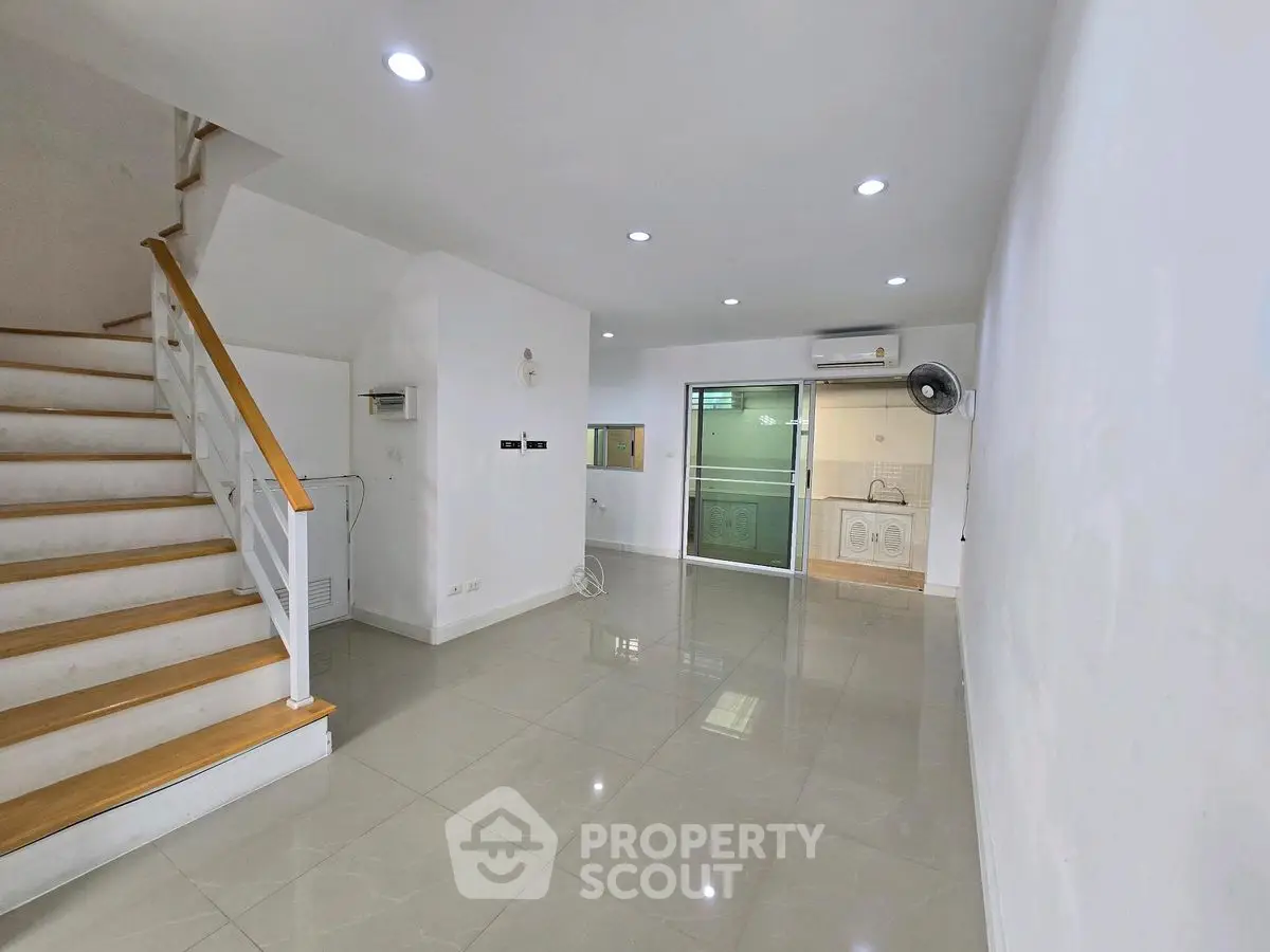 Spacious modern living room with staircase and sleek tiled flooring