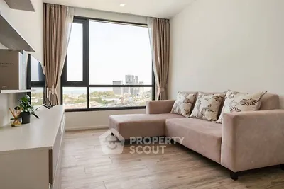 Modern living room with large window and city view, featuring a stylish sofa and wooden flooring.