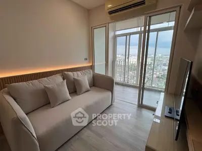 Modern living room with city view and cozy sofa in high-rise apartment.