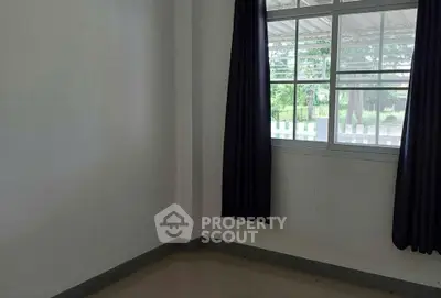 Spacious empty room with large window and dark curtains, perfect for customization.