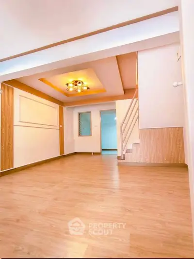 Spacious living room with modern lighting and wooden flooring in a stylish home.
