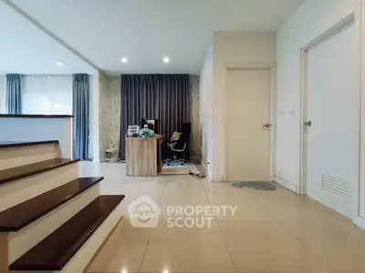 Spacious modern living area with sleek flooring and home office setup