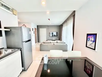 Modern open-plan living room with sleek kitchen and cozy seating area