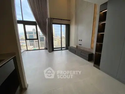Spacious modern living room with floor-to-ceiling windows and stunning city view