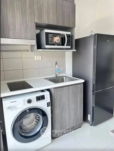 Modern kitchen with washing machine, microwave, and sleek cabinetry