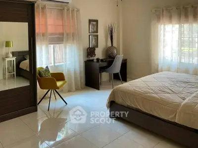 Spacious bedroom with modern decor and ample natural light