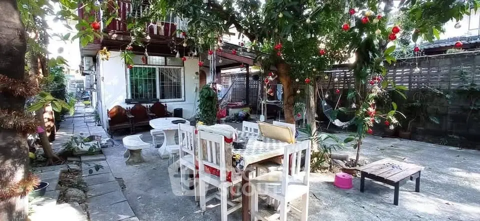 Charming backyard with outdoor seating and lush greenery, perfect for relaxation and entertaining.