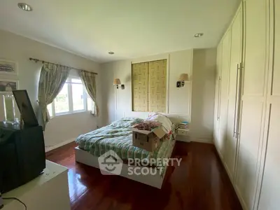 Cozy bedroom with wooden flooring and ample natural light