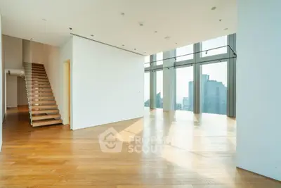 Spacious modern living room with floor-to-ceiling windows and city skyline view