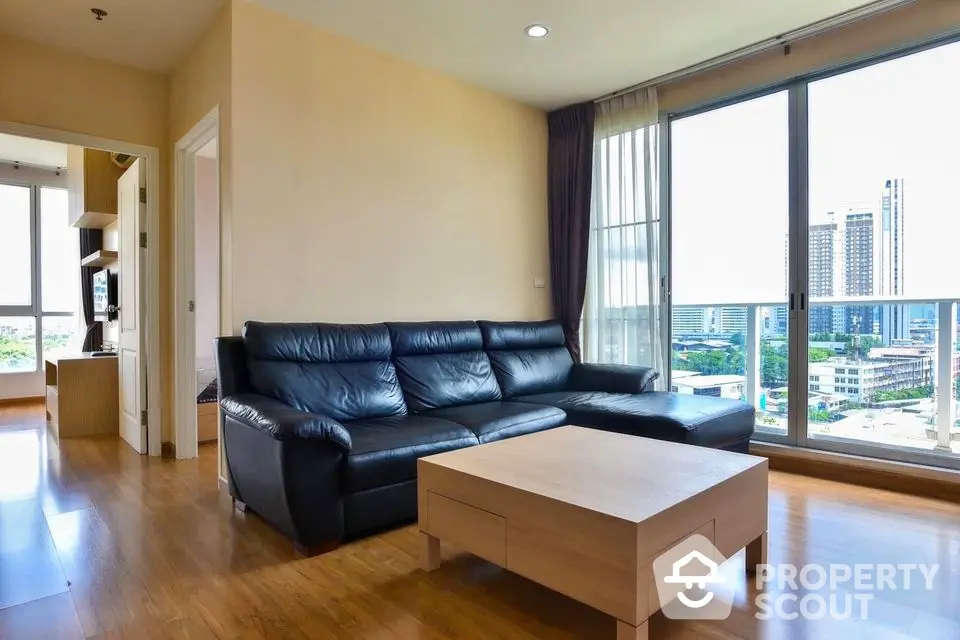 Spacious modern living room with city view and sleek black leather sofa