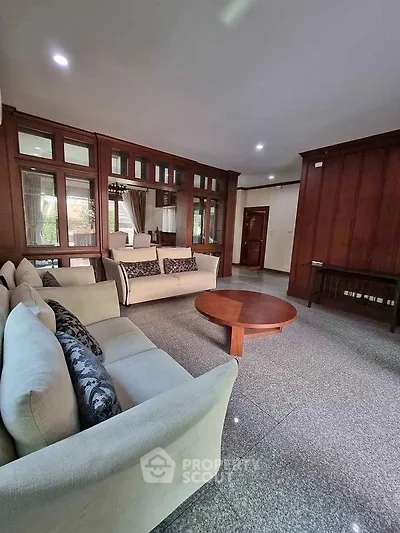 Spacious living room with elegant wooden paneling and cozy sofas