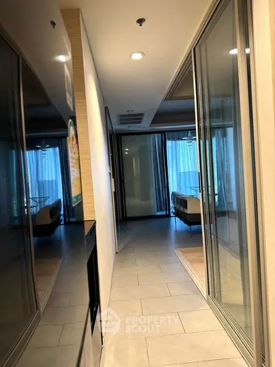 Modern apartment hallway with glass doors and tiled flooring