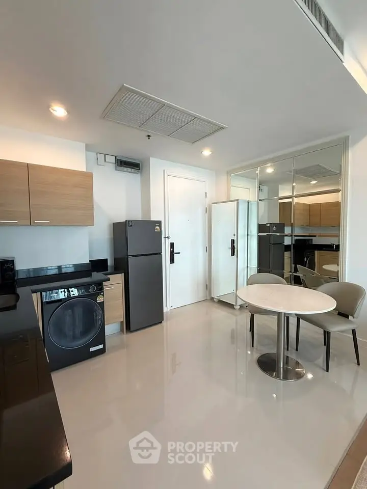 Modern kitchen with sleek appliances and dining area in stylish apartment