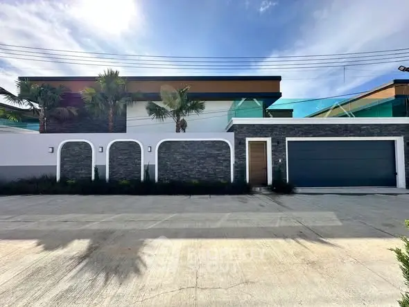 Modern luxury home exterior with sleek design and spacious driveway.