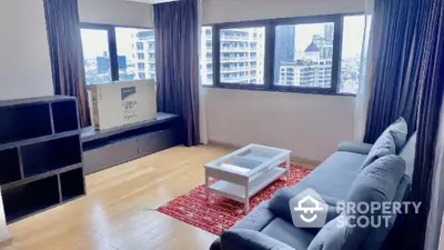 Spacious living room with city view, modern sofa, and wooden flooring.