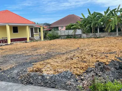 Spacious residential land plot with adjacent houses, ideal for new construction in a serene neighborhood.