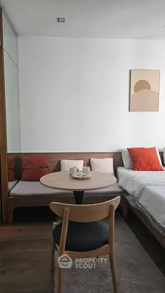 Cozy modern bedroom with stylish decor and compact dining area, perfect for urban living.