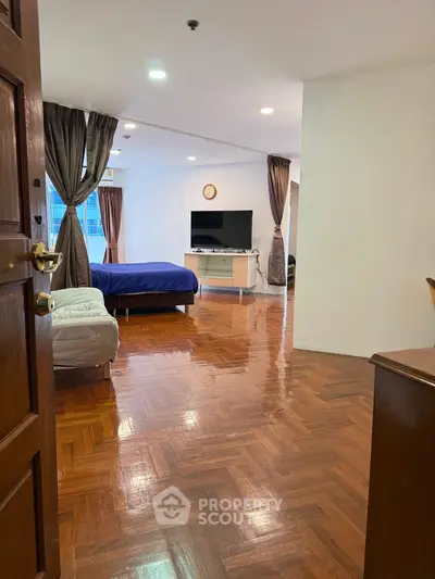 Spacious living area with polished wooden floors and modern furnishings