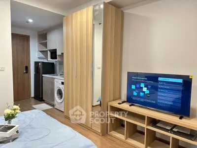 Modern studio apartment with sleek wooden flooring, mirrored wardrobe, and compact kitchen area.