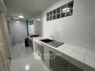 Spacious kitchen with sleek white tiles and modern fixtures