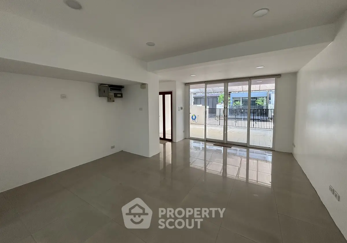 Spacious empty living room with large windows and glossy tiled floor