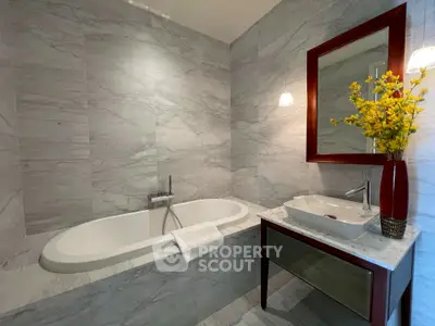 Luxurious bathroom with elegant marble tiles and modern fixtures, featuring a stylish bathtub and chic vanity.