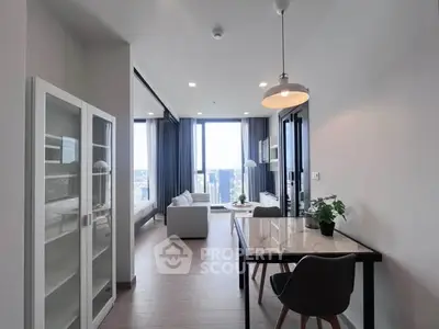Modern open-plan living room with dining area and city view, featuring sleek furniture and large windows.