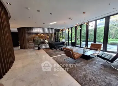Luxurious modern living room with floor-to-ceiling windows and elegant furnishings, offering a serene garden view.