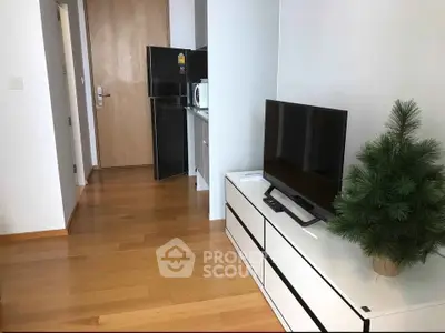 Modern living room with sleek TV stand and compact kitchen area