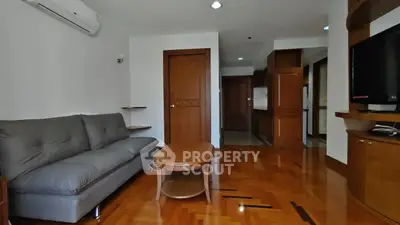 Spacious living room with wooden flooring and modern furniture in a stylish apartment.