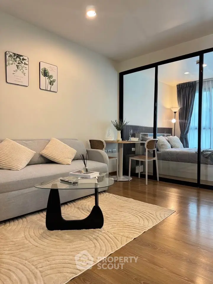 Modern living room with glass partition and cozy bedroom view