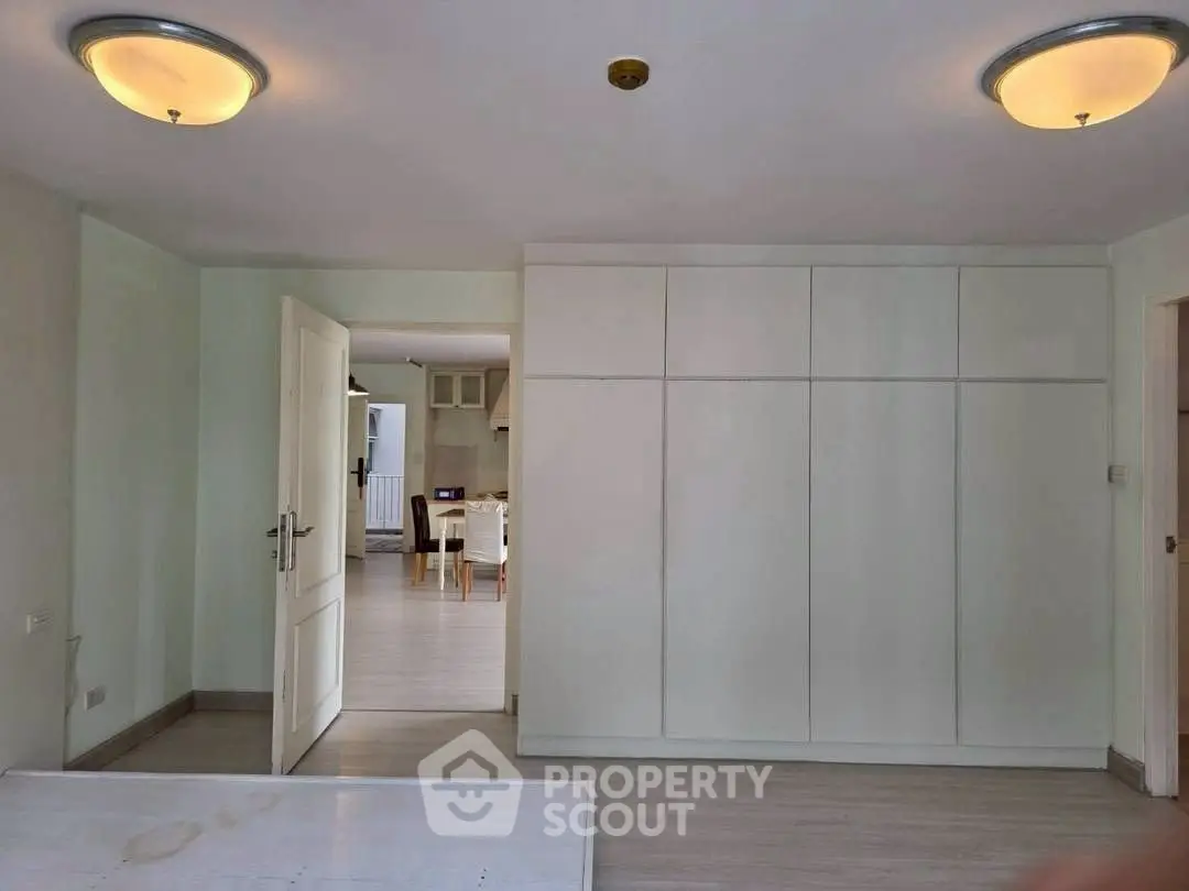 Spacious interior with modern lighting and built-in storage, leading to a bright dining area.