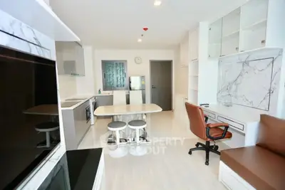 Modern open-plan kitchen and living area with sleek design and marble accents.